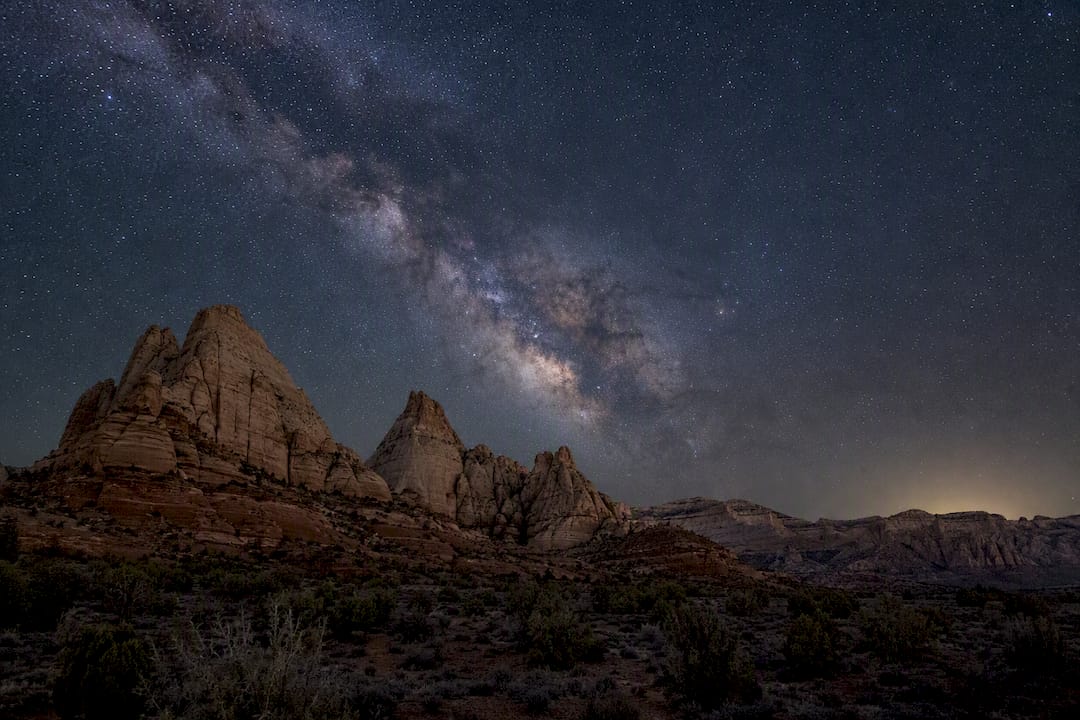 Star-filled night sky over red rock formations in Utah park