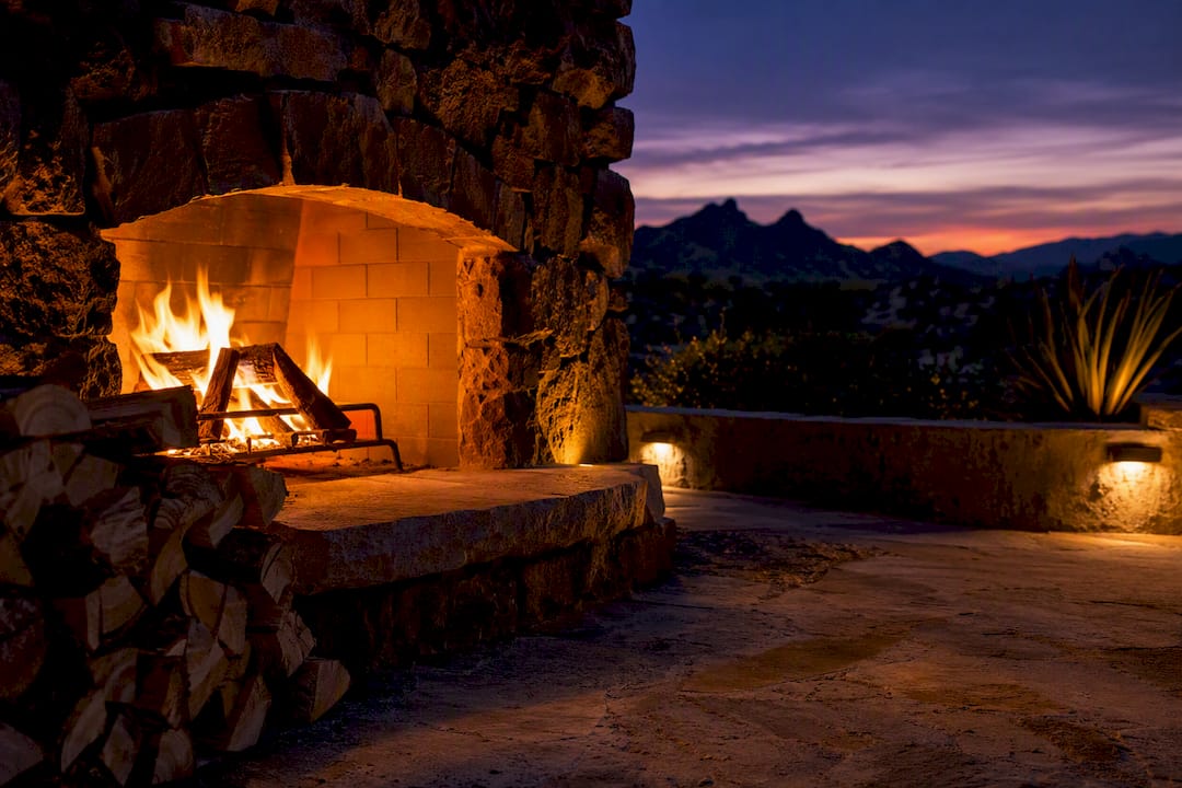 Outdoor wood fireplace with starter firewood at dusk