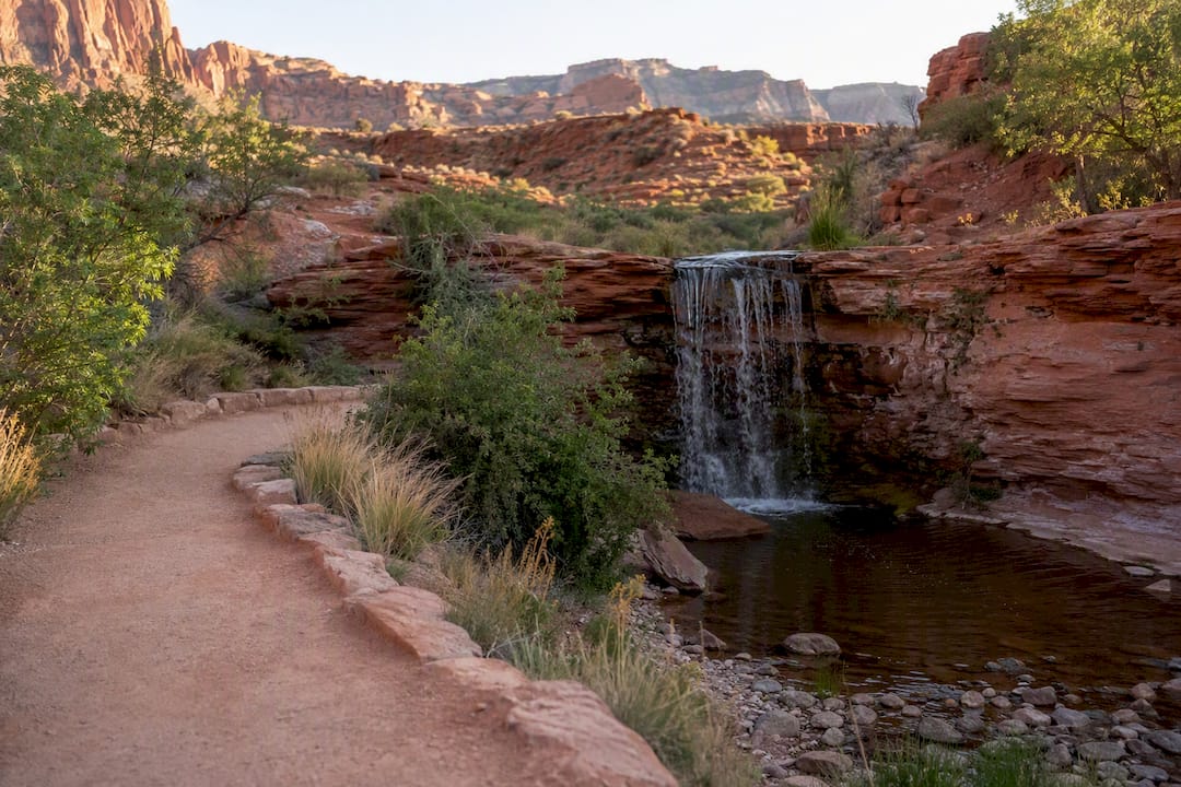 Shaded creek trail with waterfall and pools