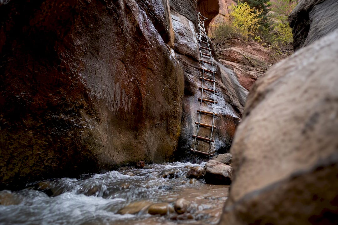Slot canyon ladder and rope over creek