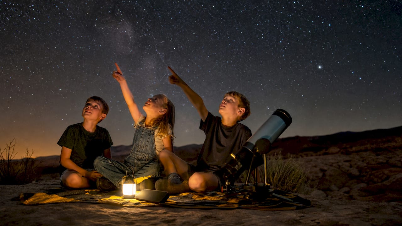 Family stargazing with binoculars and star chart app